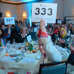 Community members raise the paddle at LWSF's Spring Benefit