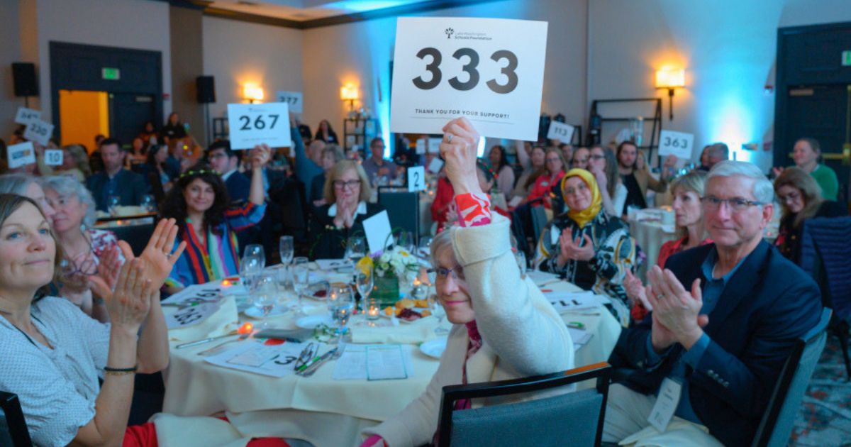 Community members raise the paddle at LWSF's Spring Benefit